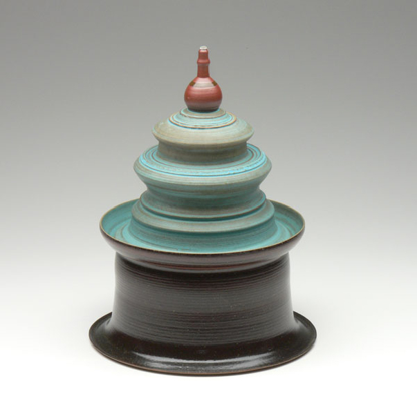 turquoise and black tiered covered jar with red finial